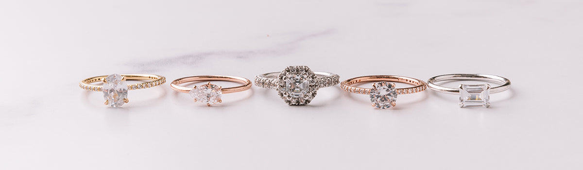 Engagment rings shown in a round cut diamond and a princess cut diamond on the model